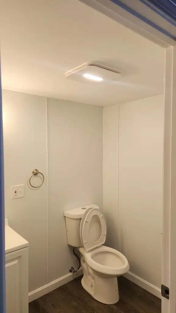 Finished basement bathroom with exhaust fan light over the toilet