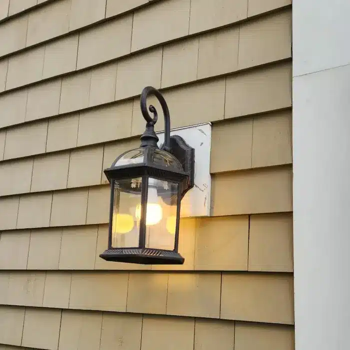 Outdoor wall lantern light fixture installed on cedar shingle siding